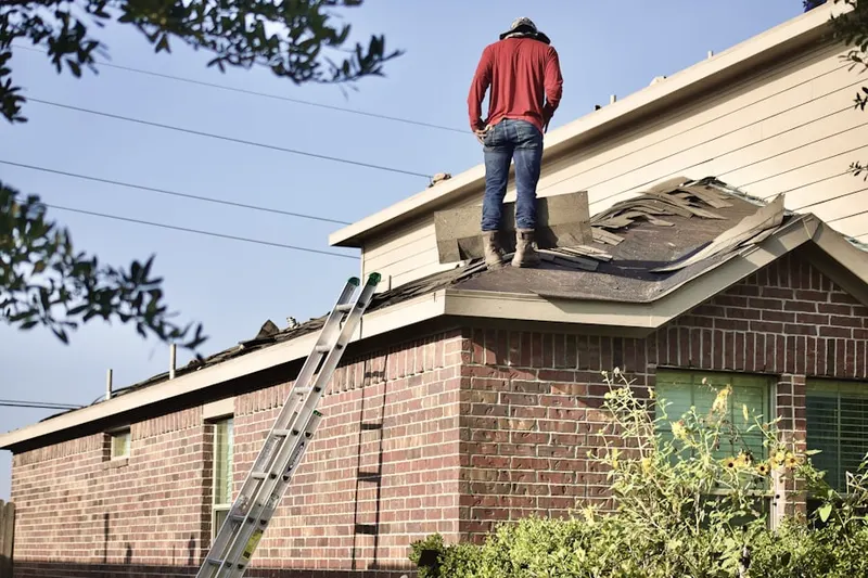 Professional roofer working on a residential roof in Highland Hills